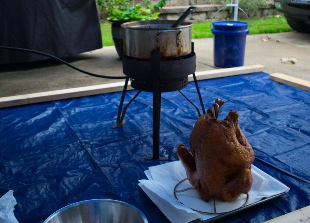 PitMaster using a premium outdoor propane deep fryer for turkey and seafood cooking in a backyard setup