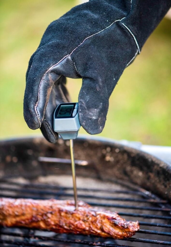 beginner pitmaster using bbq accessories including meater thermometer and grilling tools