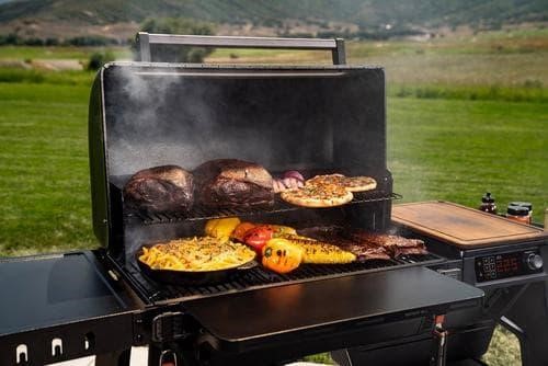 Traeger pellet grills smoking ribs and brisket in a backyard BBQ setup